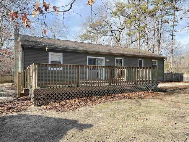 view of front of house with a wooden deck and a front yard