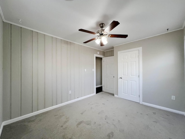 unfurnished bedroom featuring crown molding, light colored carpet, and ceiling fan