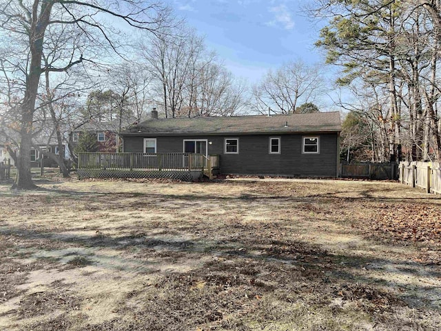 rear view of property with a wooden deck and a lawn