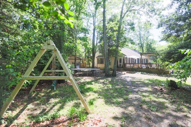 14 Freedom Dr, Erma, NJ 08204 - view of yard featuring a trampoline, a deck, an outdoor structure, and a shed
