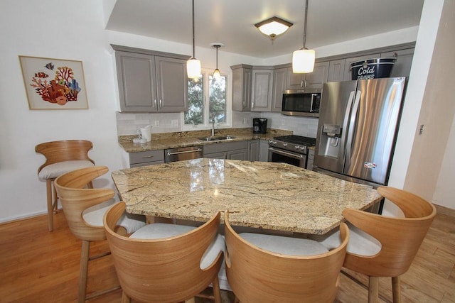 kitchen featuring backsplash, hanging light fixtures, a kitchen island, and stainless steel appliances