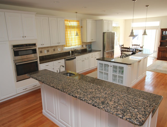 kitchen with appliances with stainless steel finishes, white cabinetry, and a large island