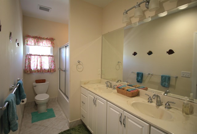 full bathroom with tile patterned flooring, vanity, combined bath / shower with glass door, and toilet