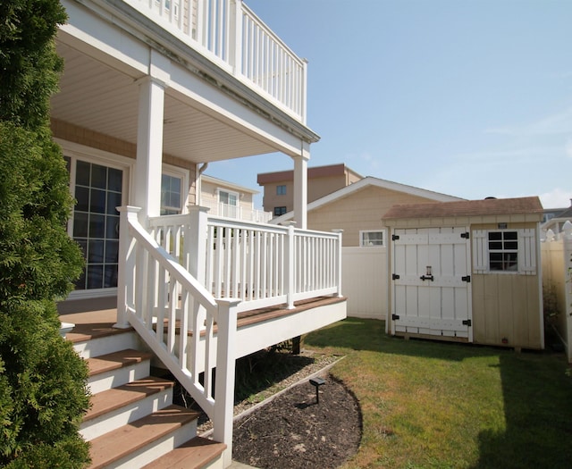 view of side of property with a yard, a shed, and a deck