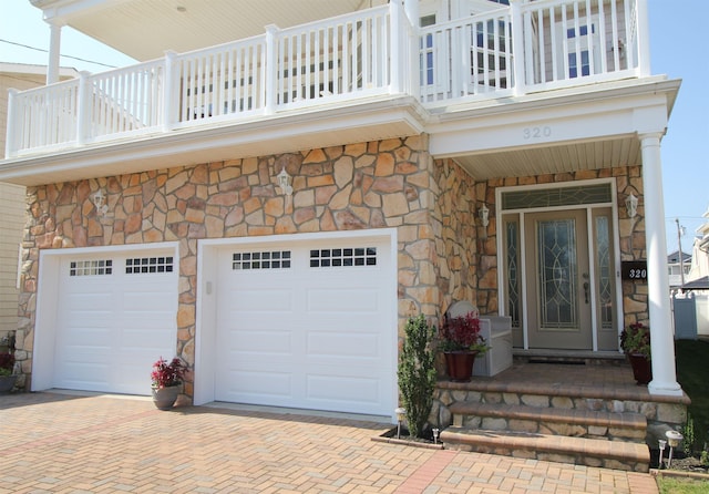 entrance to property featuring a balcony and a garage