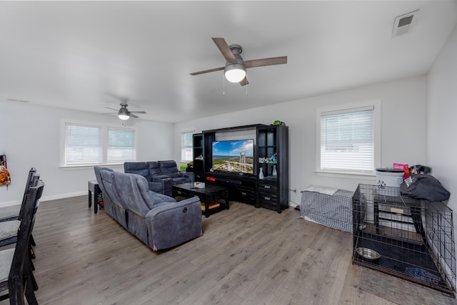 living room featuring ceiling fan and light hardwood / wood-style floors