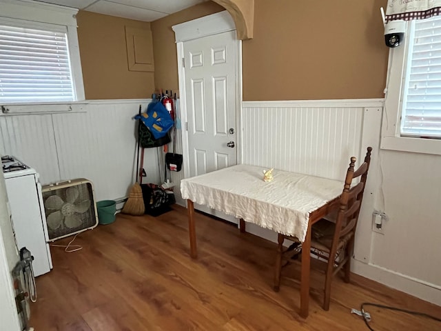 dining space with a wainscoted wall, washer / dryer, and wood finished floors