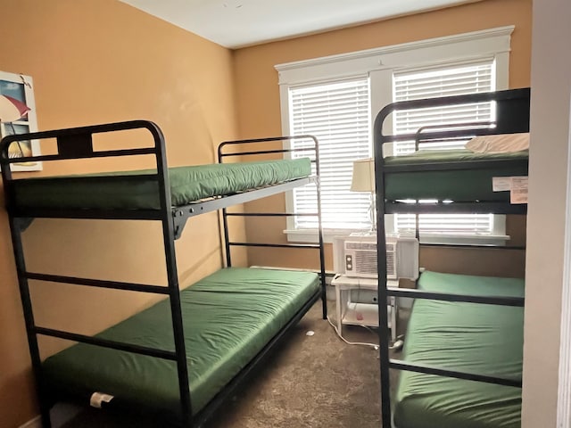 bedroom with cooling unit, multiple windows, and carpet floors