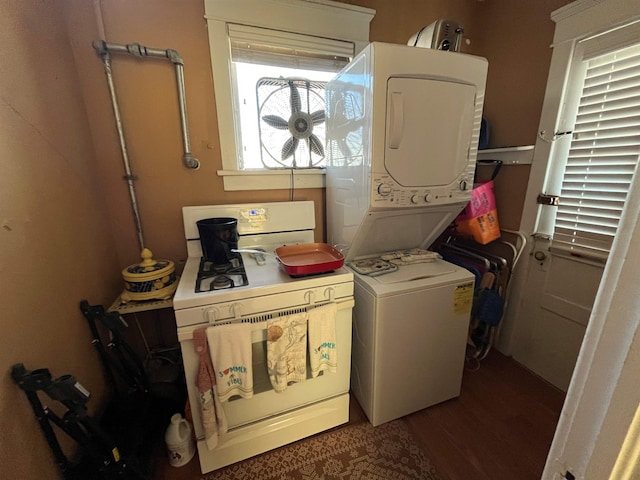 clothes washing area featuring stacked washer / dryer, laundry area, and wood finished floors