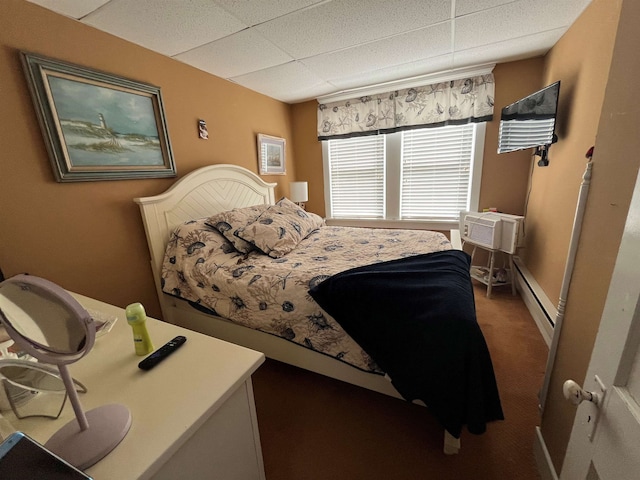 bedroom featuring a baseboard heating unit, carpet flooring, a paneled ceiling, and a wall mounted AC