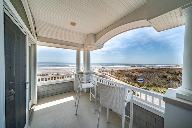 balcony featuring a water view and a beach view