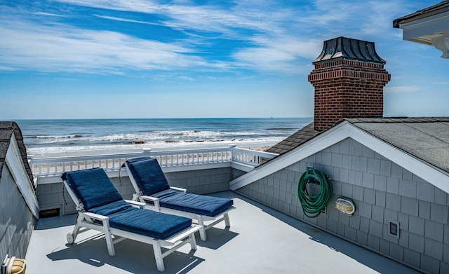 balcony featuring a view of the beach and a water view