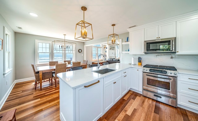 kitchen featuring a peninsula, visible vents, stainless steel appliances, and a sink