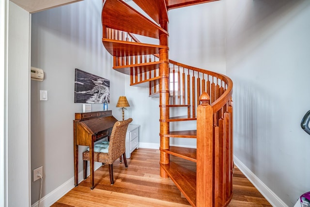 stairway featuring wood finished floors and baseboards