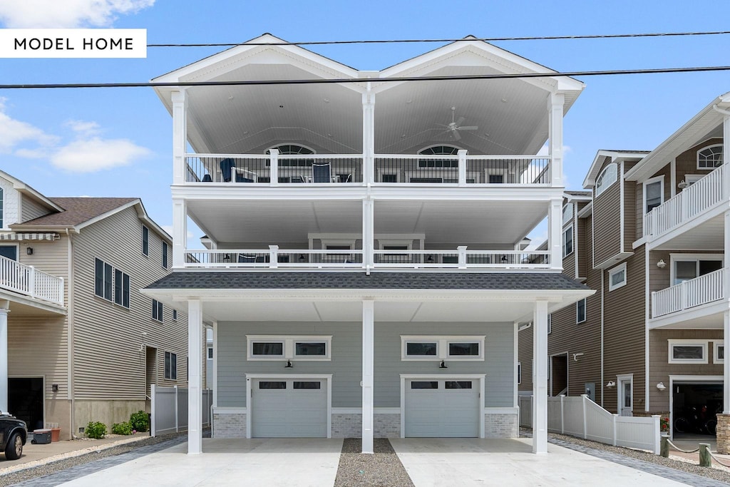 view of front of home featuring driveway, ceiling fan, a garage, and fence