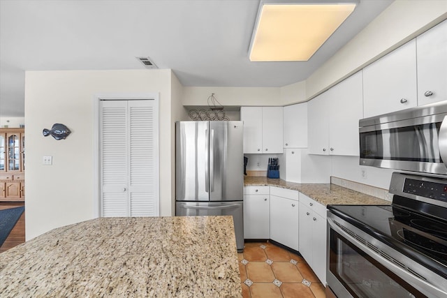9400 Roberts Ave Unit 306, Sea Isle City, NJ 08243 - kitchen with appliances with stainless steel finishes, white cabinets, light tile patterned floors, and light stone counters