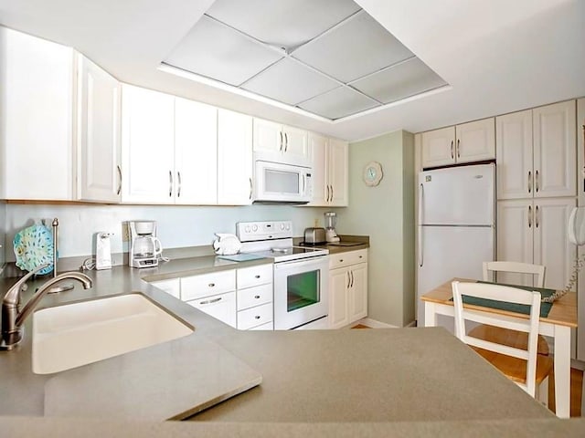 kitchen with white cabinetry, white appliances, and sink