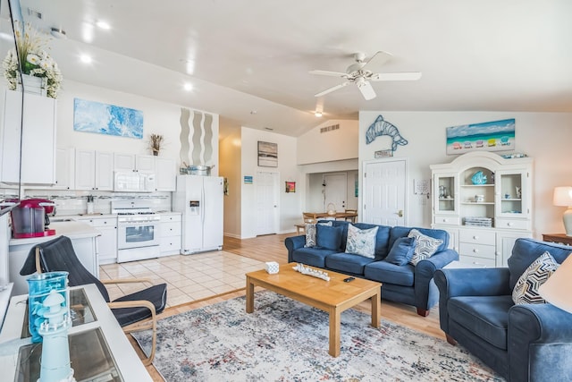 living room featuring ceiling fan, light hardwood / wood-style flooring, and vaulted ceiling