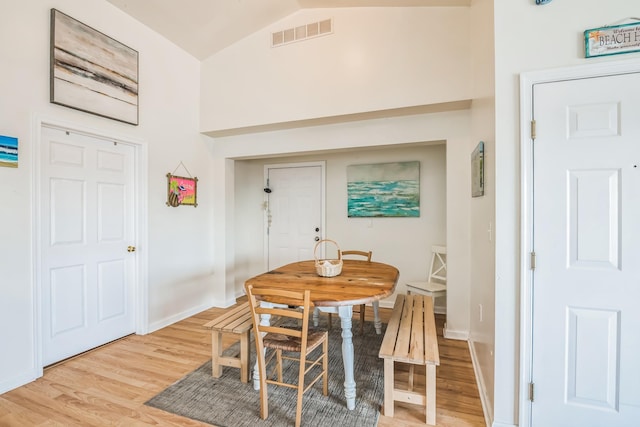 dining area with light hardwood / wood-style floors and lofted ceiling