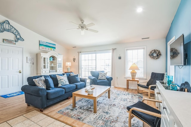 living room with light wood-type flooring, vaulted ceiling, and ceiling fan