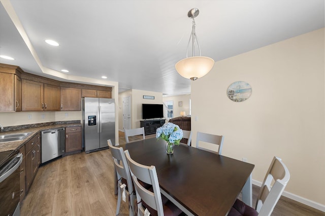 dining room with sink and light hardwood / wood-style flooring