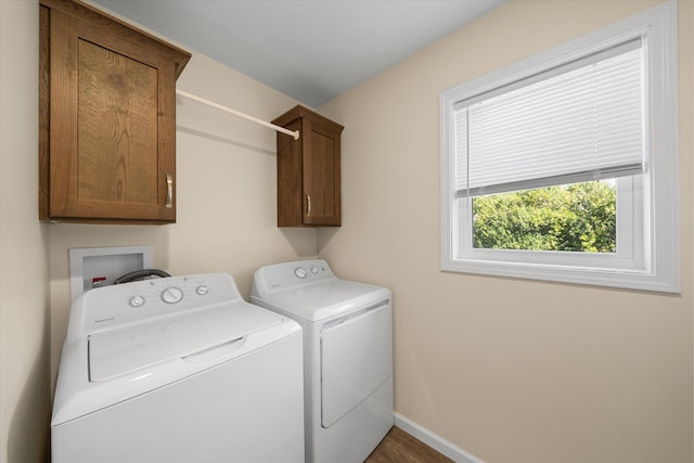 clothes washing area featuring dark hardwood / wood-style floors, cabinets, and separate washer and dryer