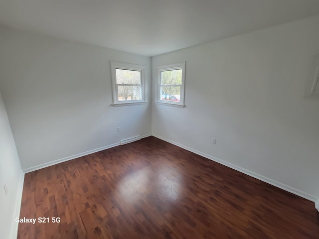 empty room with dark hardwood / wood-style flooring