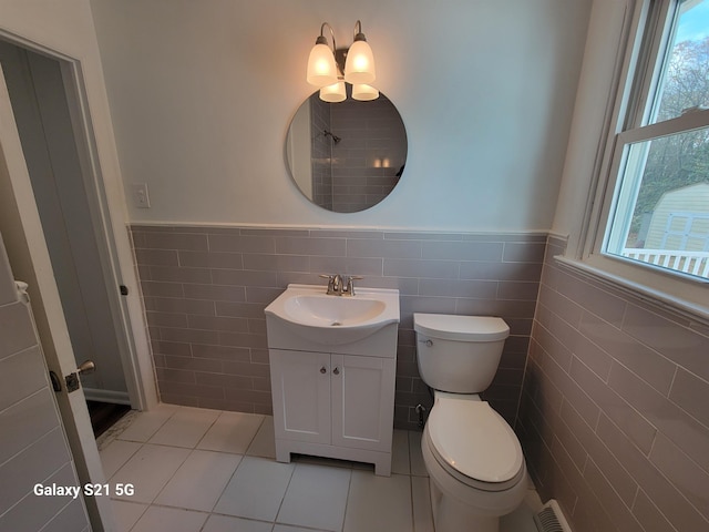 bathroom with tile patterned flooring, vanity, tile walls, and toilet