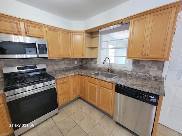 kitchen with sink, decorative backsplash, stainless steel appliances, and dark stone counters