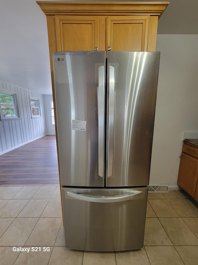 kitchen featuring stainless steel fridge and light tile patterned flooring