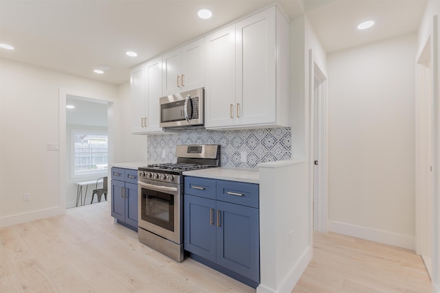 kitchen featuring light wood finished floors, white cabinetry, appliances with stainless steel finishes, and tasteful backsplash