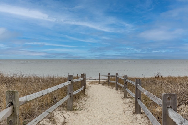 surrounding community featuring a water view and fence