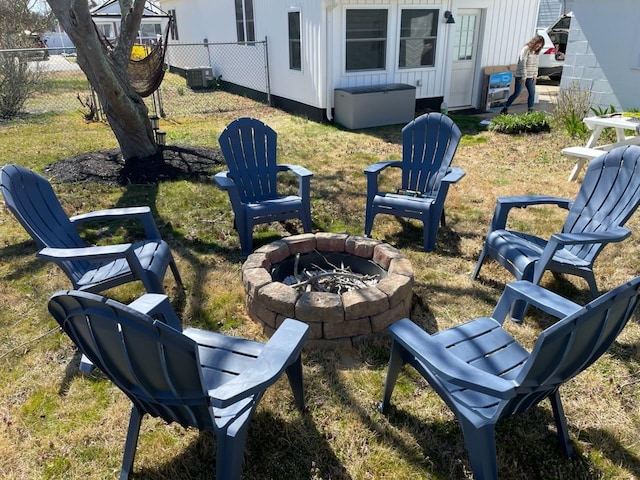 view of yard with central air condition unit, an outdoor fire pit, and fence