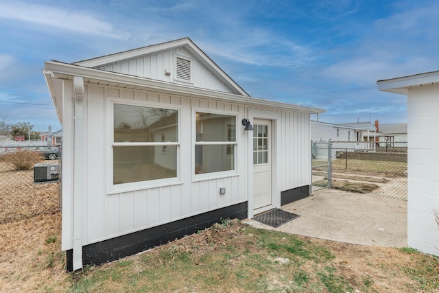 view of side of home with fence and board and batten siding