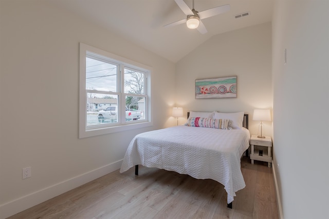 bedroom with visible vents, baseboards, lofted ceiling, ceiling fan, and wood finished floors