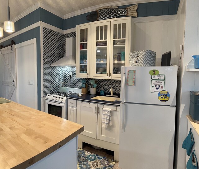 kitchen with white appliances, a textured ceiling, radiator heating unit, wood finished floors, and ornamental molding
