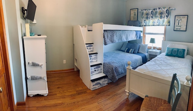 bedroom with baseboards and wood finished floors