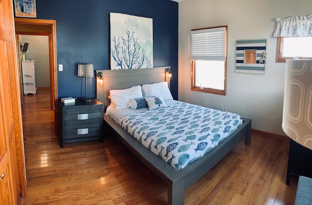 bedroom with baseboards and hardwood / wood-style flooring