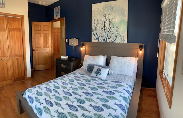 bedroom with baseboards, a closet, and wood finished floors