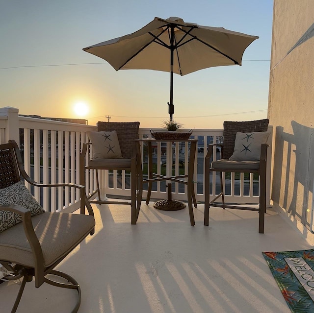 patio terrace at dusk featuring a balcony