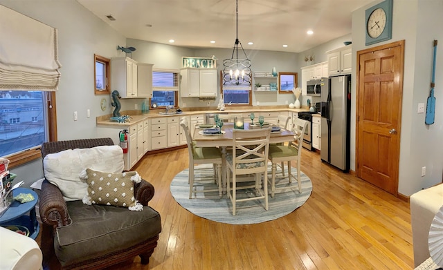 kitchen featuring light countertops, white cabinetry, a chandelier, a sink, and appliances with stainless steel finishes