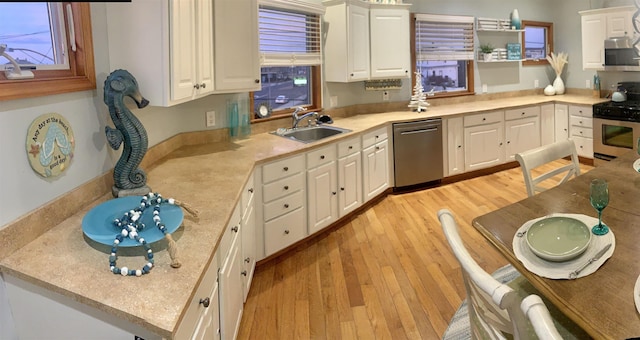 kitchen with light wood-type flooring, a sink, light countertops, stainless steel appliances, and white cabinetry