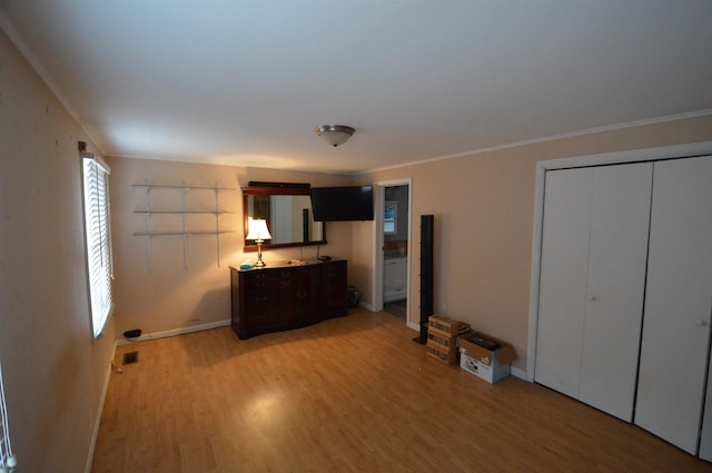 unfurnished bedroom featuring wood-type flooring, a closet, and crown molding