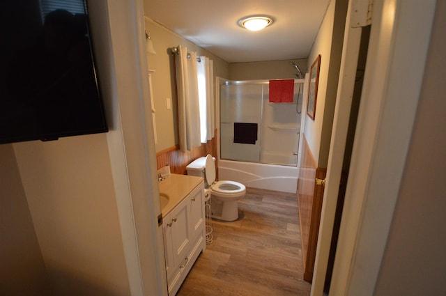 full bathroom with bath / shower combo with glass door, toilet, vanity, and wood-type flooring