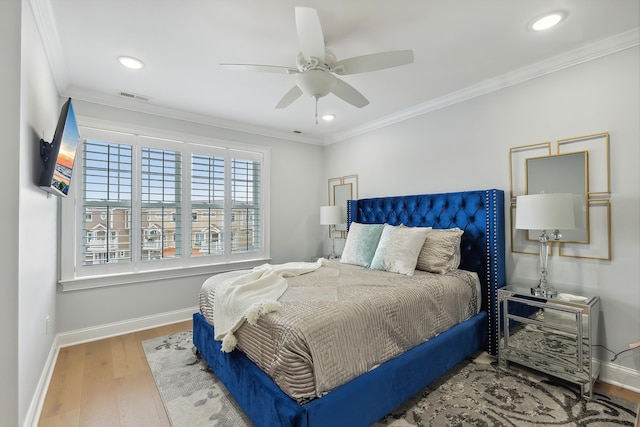 bedroom with recessed lighting, crown molding, baseboards, and wood finished floors