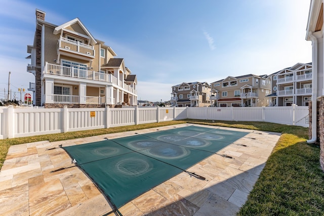 view of swimming pool featuring a residential view and fence