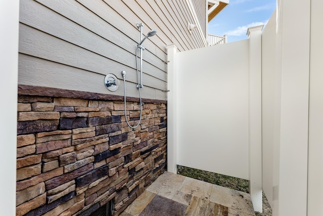 bathroom with tiled shower and stone tile flooring