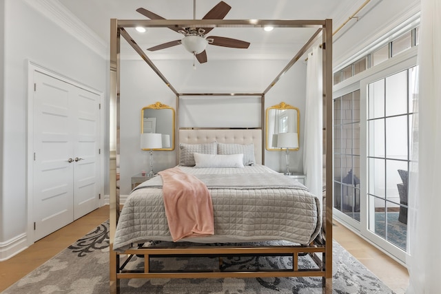 bedroom featuring multiple windows, a ceiling fan, wood finished floors, and crown molding