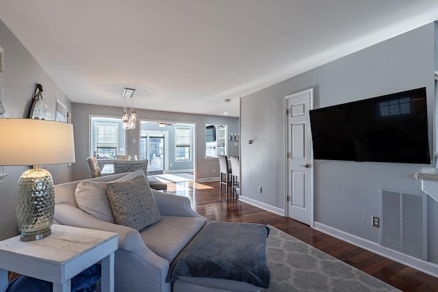 living area featuring a ceiling fan, baseboards, visible vents, and wood finished floors