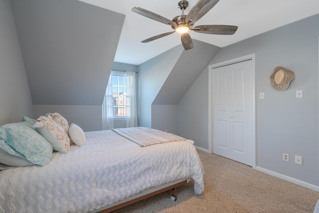 bedroom with lofted ceiling, carpet floors, a ceiling fan, baseboards, and a closet